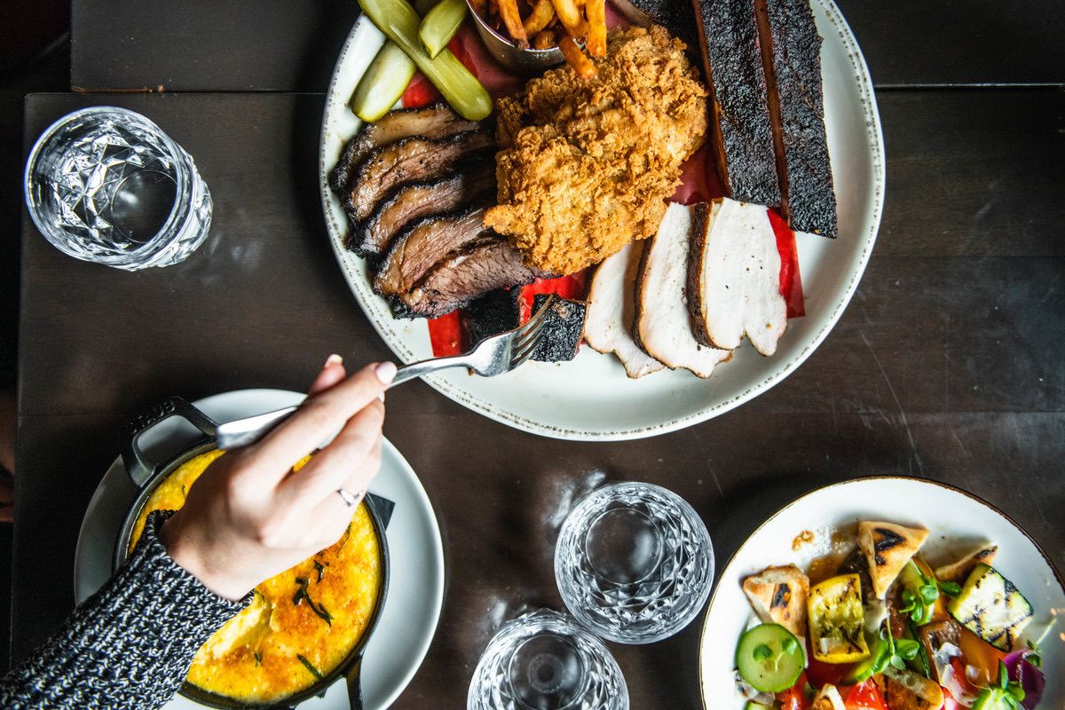 Carbon Bar family-style barbecue platter with brisket, ribs, chicken, and sides